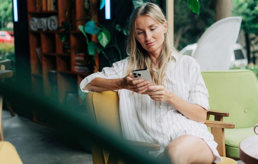 woman on her phone considering her limiting beliefs